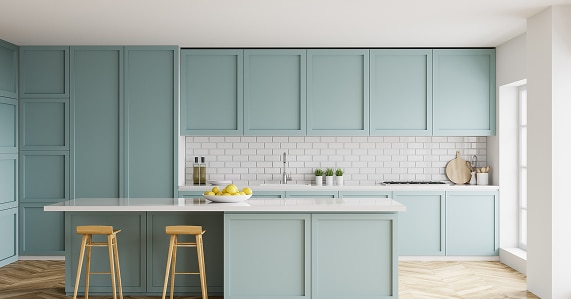 Armoires bleu sarcelle : design de cuisine moderne avec îlot Cuisine moderne bleu sarcelle/vert d'eau. Armoires à panneaux, îlot central blanc, dosseret carreaux métro. Sol bois chevron. Citrons sur l'îlot.