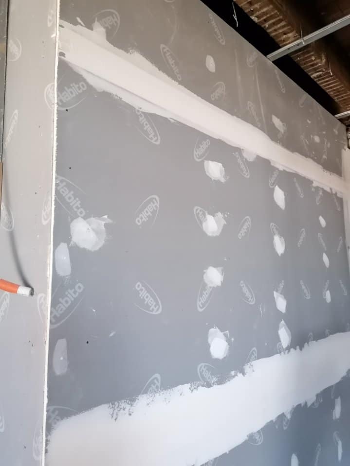 Plaque de plâtre Habito avec enduit de jointoiement blanc sur vis et raccords de cloison en cours de rénovation.