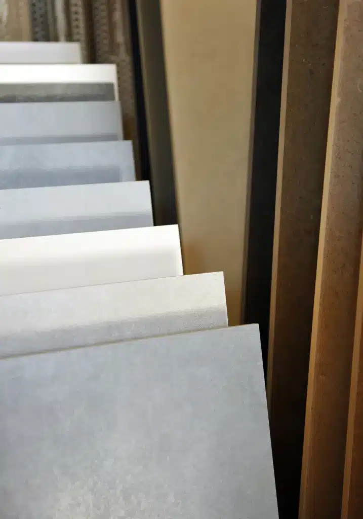 Carrelage Grès Cérame : Large Sélection de Couleurs et Styles Échantillons de carrelage en grès cérame aux tons gris et beige présentés dans un showroom de décoration.